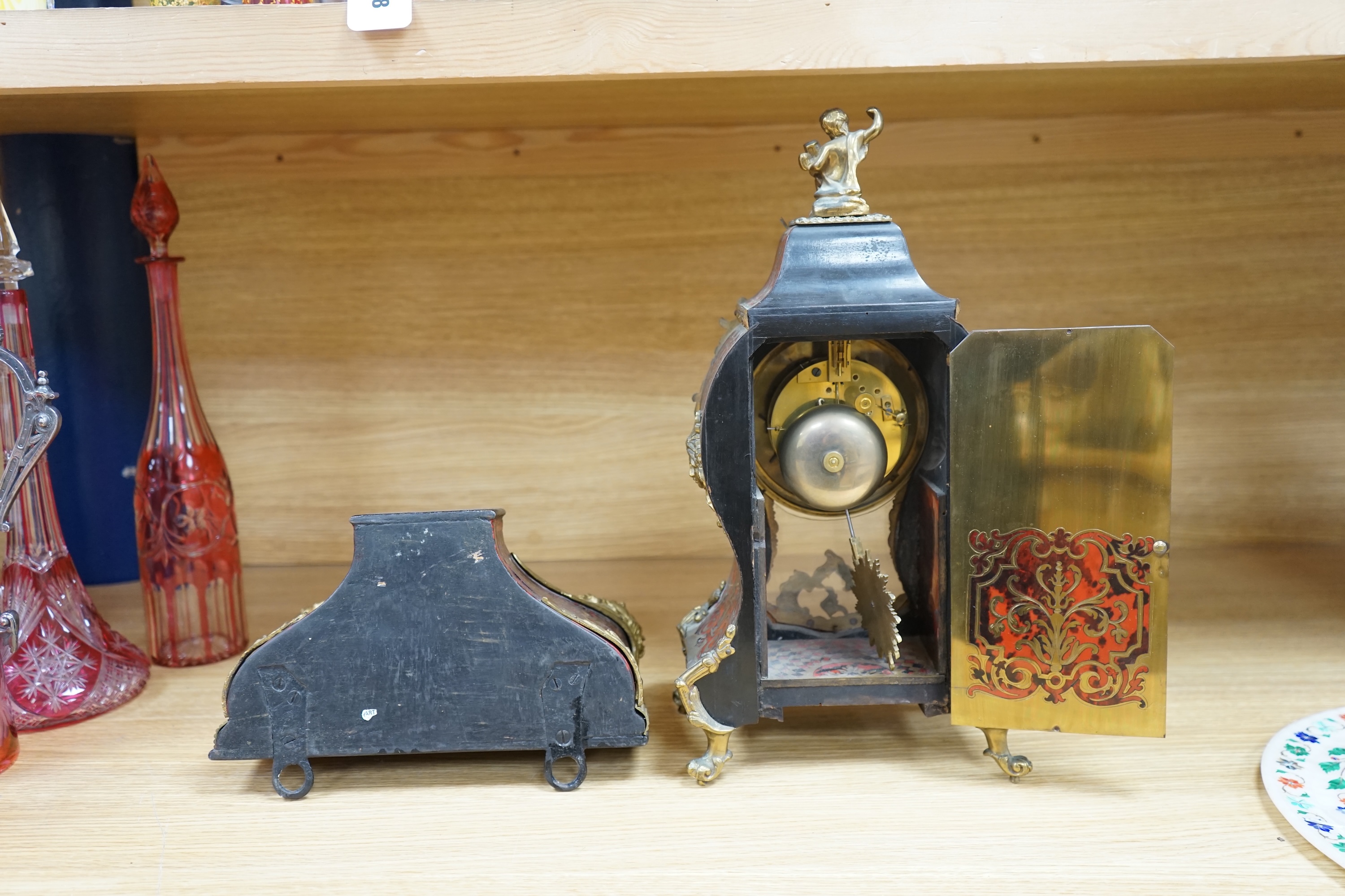 A French scarlet Boulle clock, and original bracket, the waisted case with glass front enclosing boulle interior and sunburst pendulum, c. 1860, clock 42cm high. Condition - fair, untested